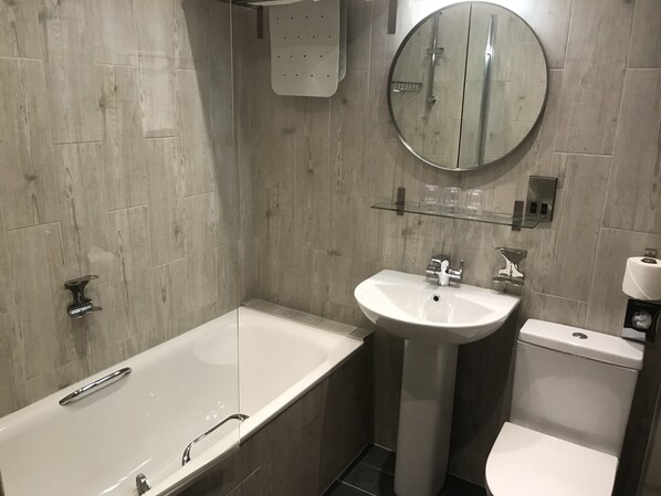 A modern bathroom with a bathtub, a sink, and a toilet.