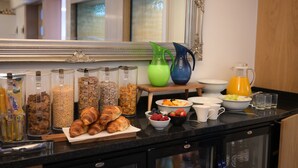 A breakfast buffet with various food items, including pastries, cereals, and fruits, and a coffee machine. - Ilfracombe Carlton Hotel - Hotel (Ilfracombe)