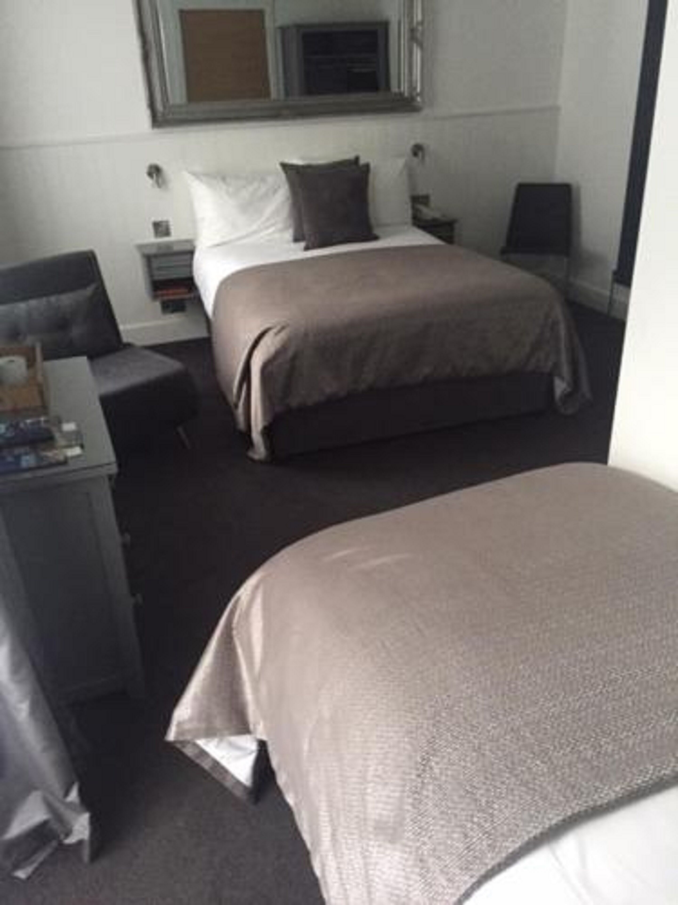 A hotel room with a bed, a desk, and a chair.