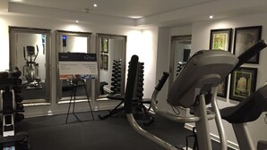 A gym with cardio equipment, weight machines, and a mirror. - Ilfracombe Carlton Hotel - Hotel (Ilfracombe)