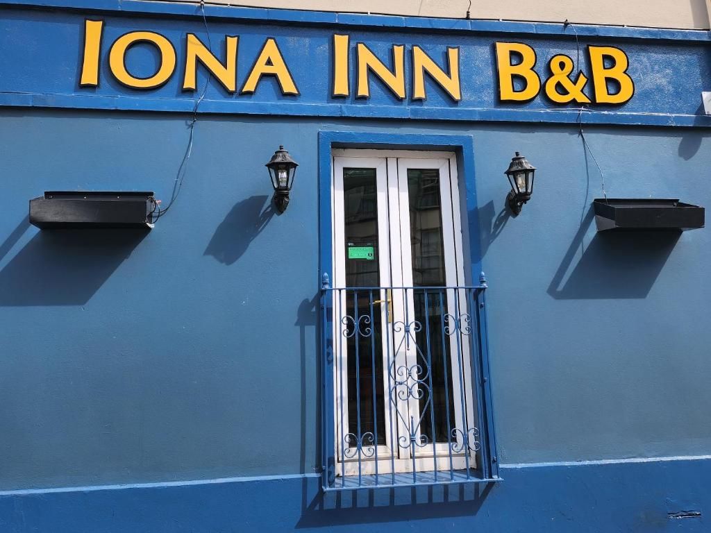 A building with a blue exterior and a sign reading 'IONA INN B&B'.