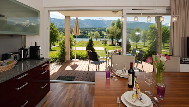 A modern kitchen with a large window overlooking a scenic landscape. - Appartements De Luxe Schluga (Hermagor-Pressegger See)