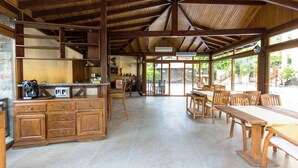 A spacious indoor area with wooden furniture, a kitchen counter, and large windows allowing natural light. - Ipek Garden Palace Residence - Boutique Class (Bodrum)