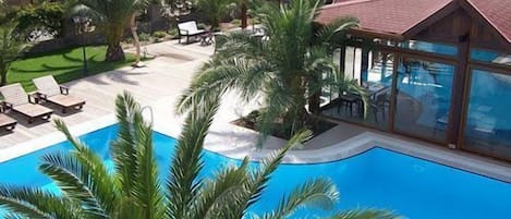 Piscine extérieure, parasols de plage, chaises longues