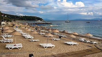 Nära stranden, solstolar, parasoller och strandhanddukar