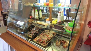 A bakery display case with various baked goods and packaged items. - Il Canneto (Porto Ceresio)