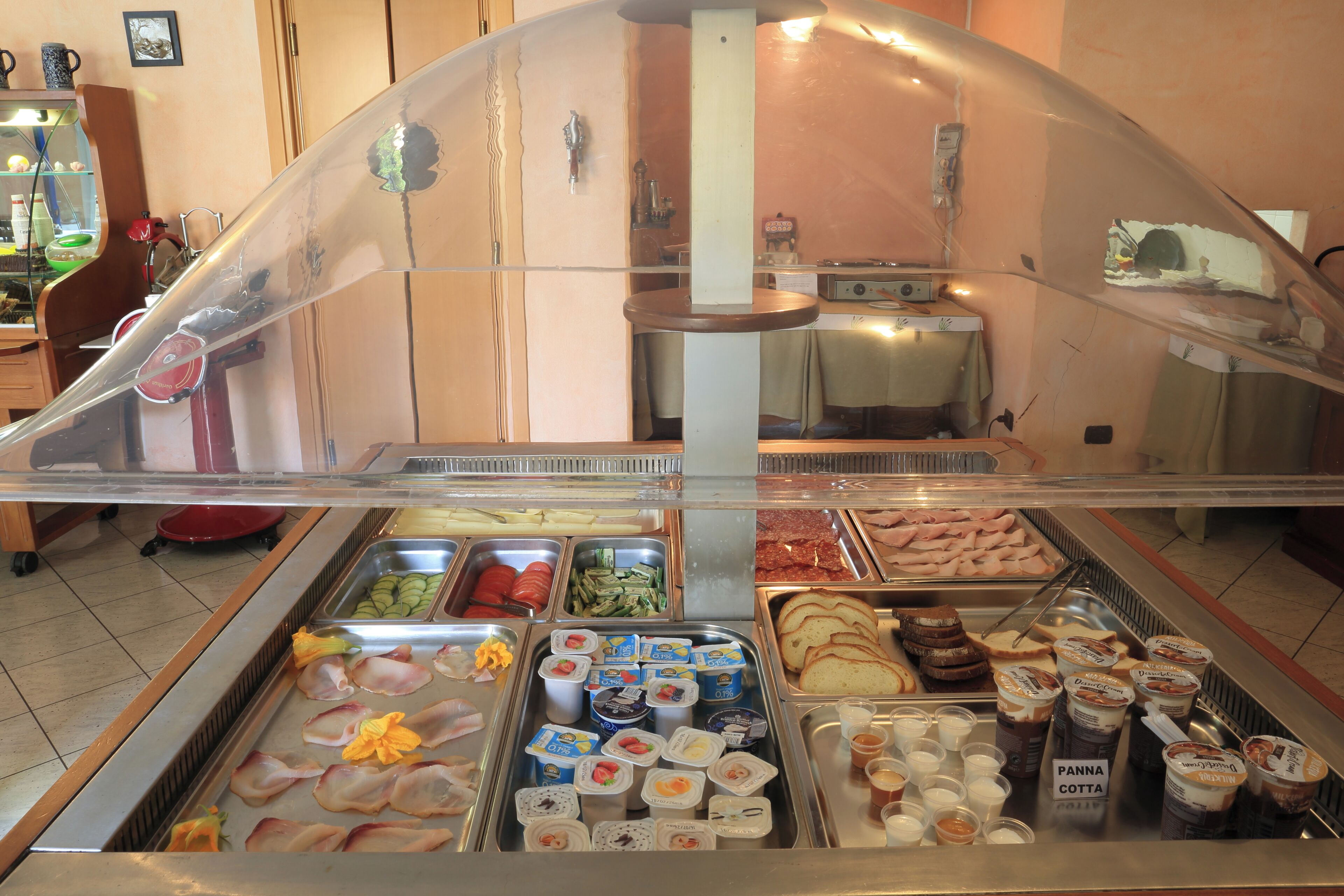 A buffet with various food options including meats, vegetables, and dairy products.
