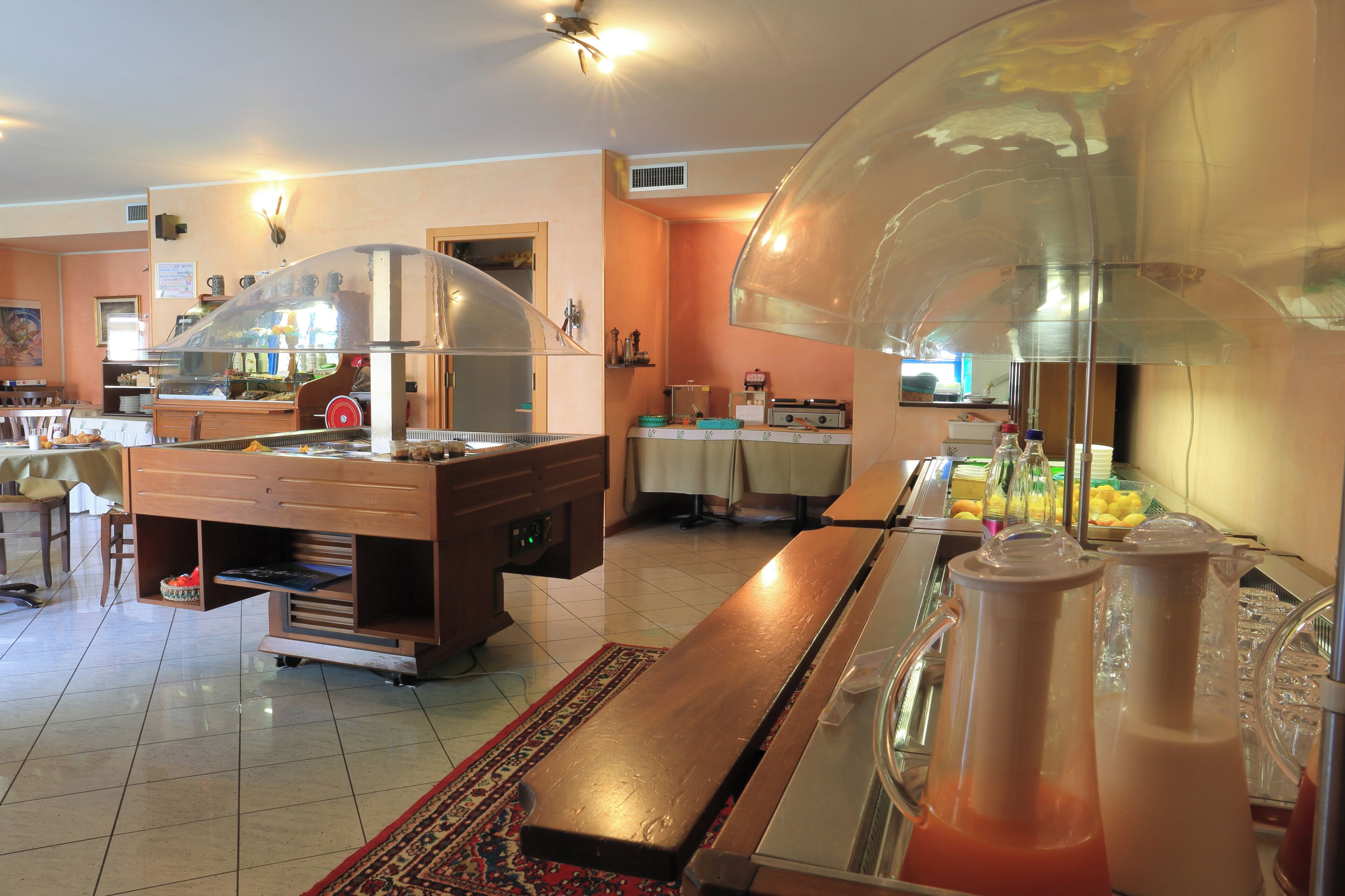 A buffet area with a counter, a coffee machine, and a refrigerator.