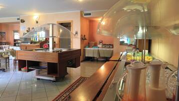 A buffet area with a counter, a coffee machine, and a refrigerator.