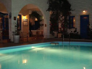Un espace piscine comprenant un comptoir d’accueil, des sièges et des arcades.