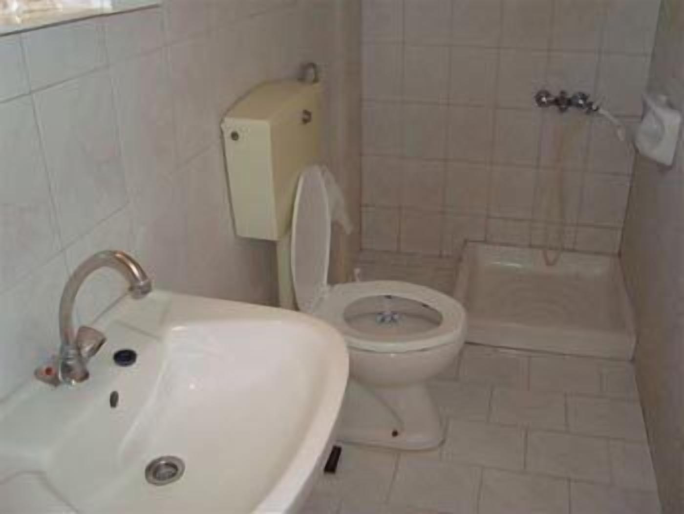 Un baño con lavamanos, inodoro y ducha.