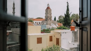 A view of a building with a tower and a mosque, through an open window. - Zacosta Villa - a Heritage Hotel (Rhodes)