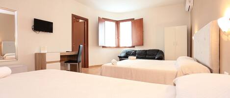 Quarto de hotel com duas camas, uma escrivaninha, uma cadeira, televisão, guarda-roupa e janela.