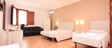 A hotel room with a bed, a desk, a chair, a wardrobe, and a window.