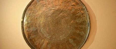 Uma placa metálica circular com desenhos e padrões elaborados.