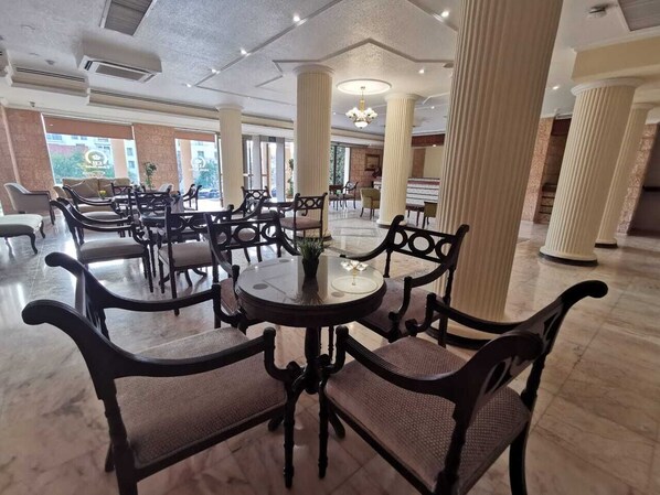 A spacious lobby with marble flooring, large columns, and classic furniture.