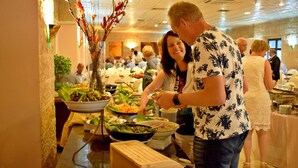 A buffet with various dishes and a decorative centerpiece. - Edom Hotel (Wadi Musa)