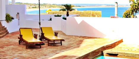 Een buitenzwembad, parasols voor strand/zwembad