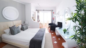 Ein modernes Hotelzimmer mit einem großen Bett, einem Schreibtisch und einem durchgegangenen Tür sichtbar liegenden Badezimmer.