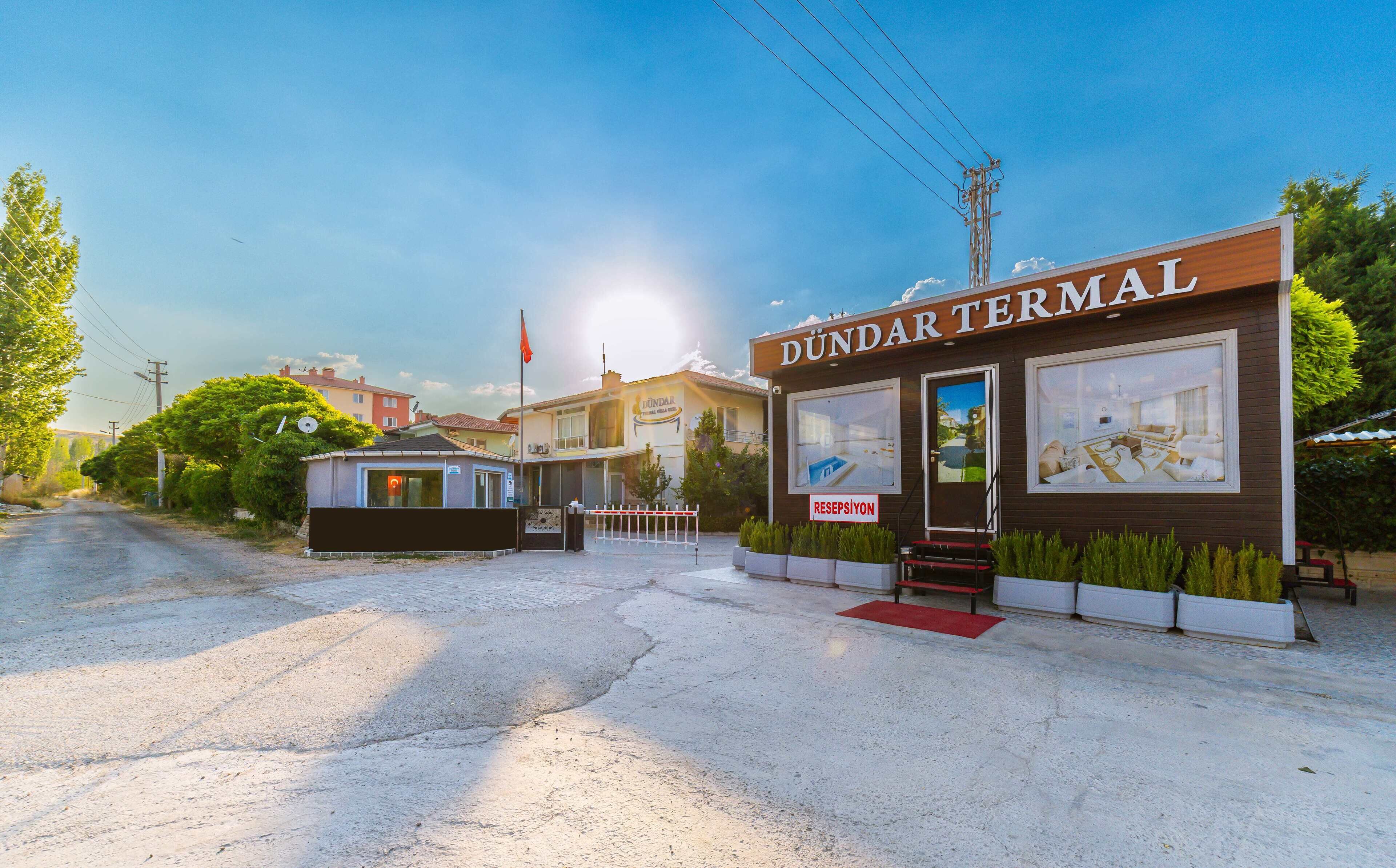 A hotel named 'DÜNDAR TERMINAL' with a modern facade, large windows, and a red carpet entrance.