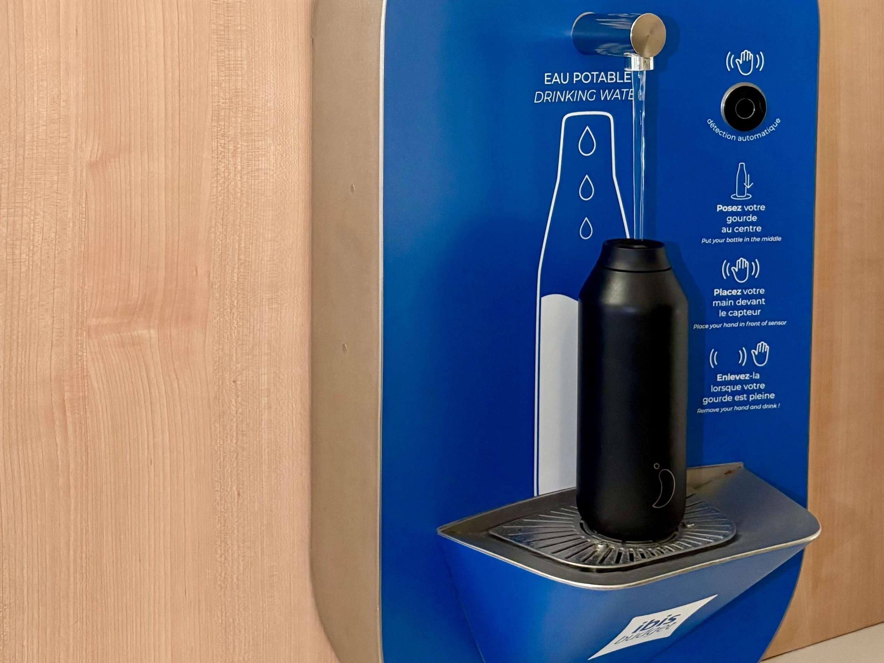 A water dispenser with instructions for use, a black bottle, and a sensor for automatic detection.