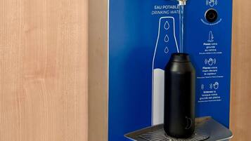 A water dispenser with instructions for use, a black bottle, and a sensor for automatic detection.