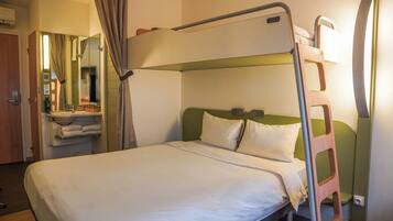 A bunk bed with a ladder, a bedside table with a mirror, and a wall-mounted shelf with towels.