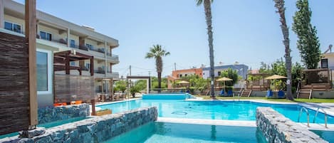 Una piscina al aire libre, tumbonas