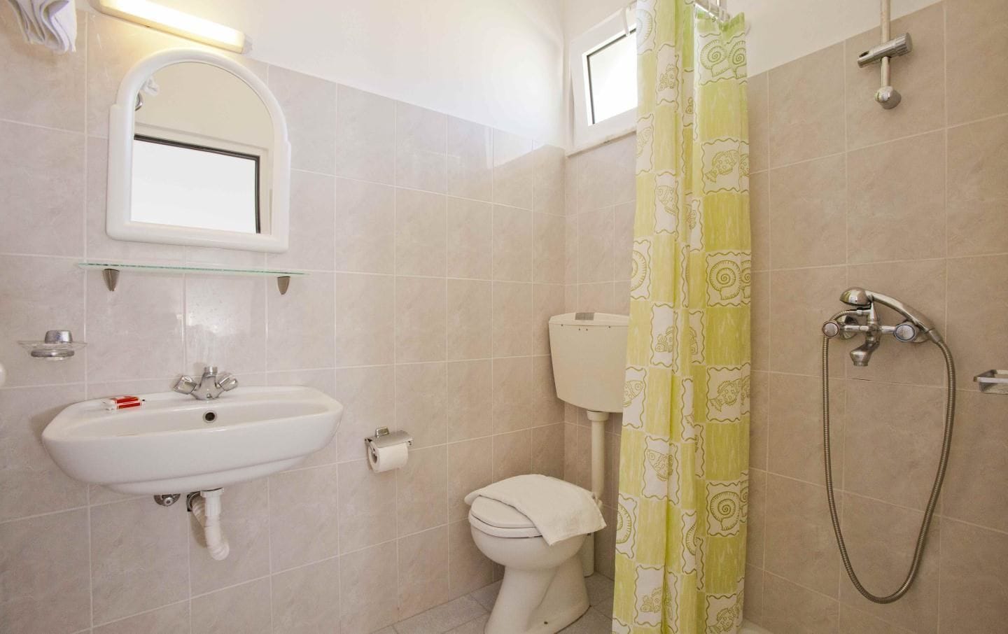 A bathroom with a sink, toilet, and shower.