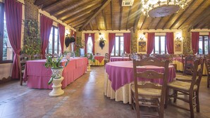 A dining hall with wooden beams, red curtains, and tables set for dining. - Las Mayoralas (Periana)