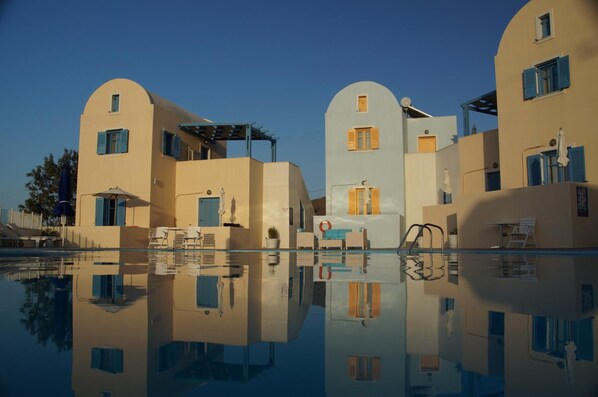 Un hotel con piscina que refleja los edificios.