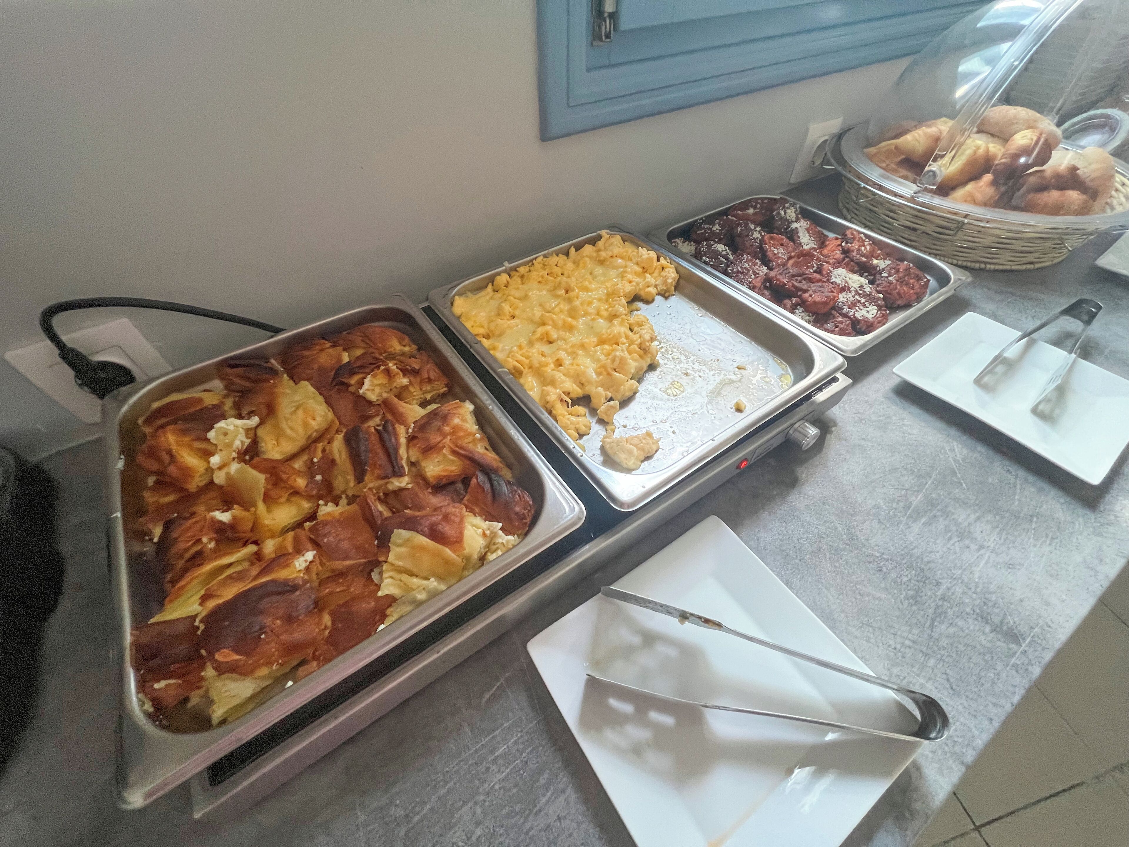 A buffet with various food items including baked goods and macaroni and cheese.