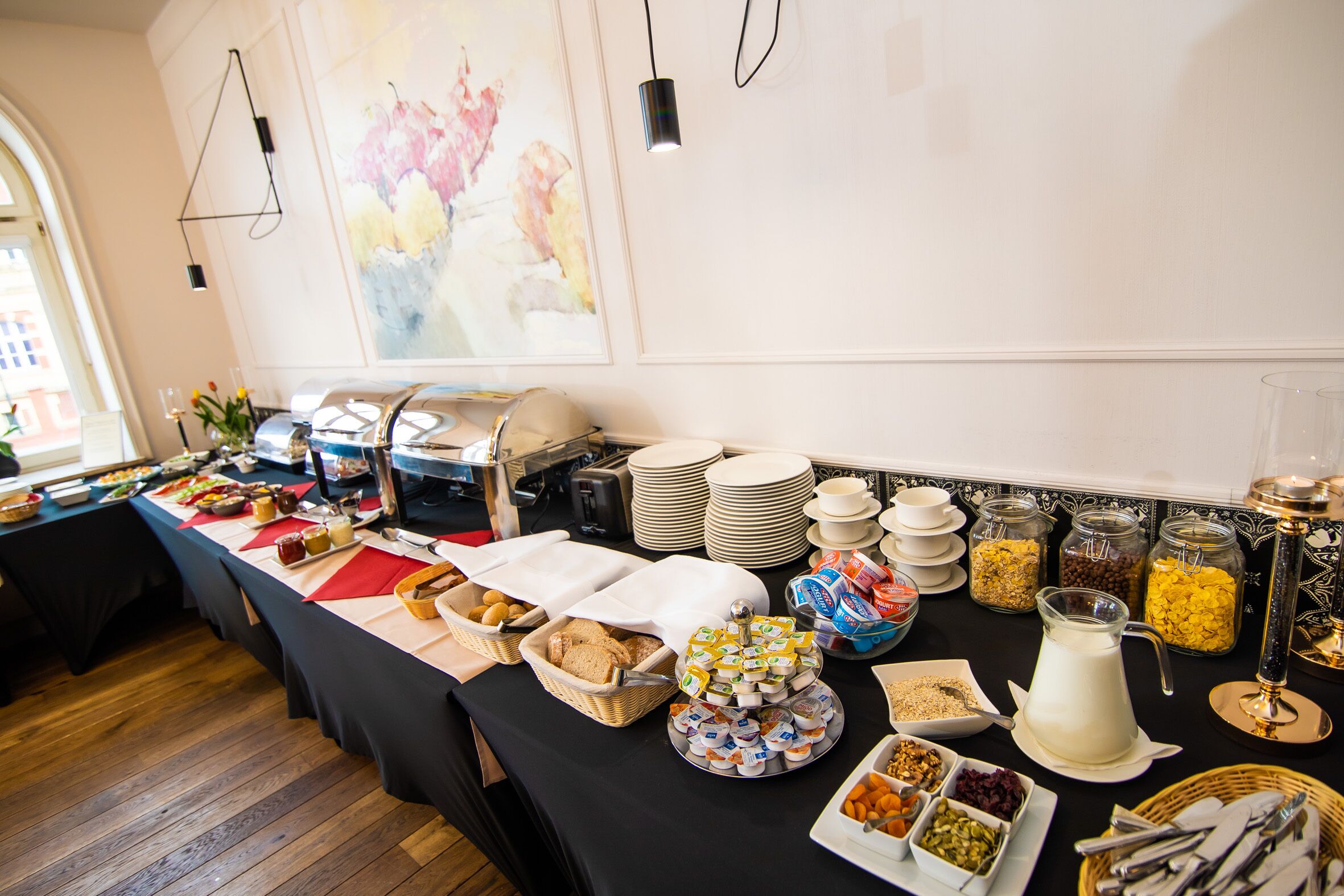 Un buffet proposant une variété de plats, d’assiettes et d’ustensiles de service.