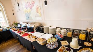 Una mesa de buffet con diferentes opciones de comida, platos y utensilios.
