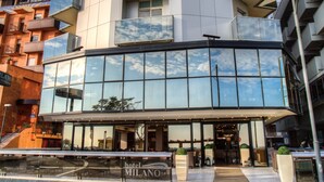 A hotel with a modern design, featuring a glass facade and multiple balconies. - Milano Resort (Bellaria-Igea Marina)