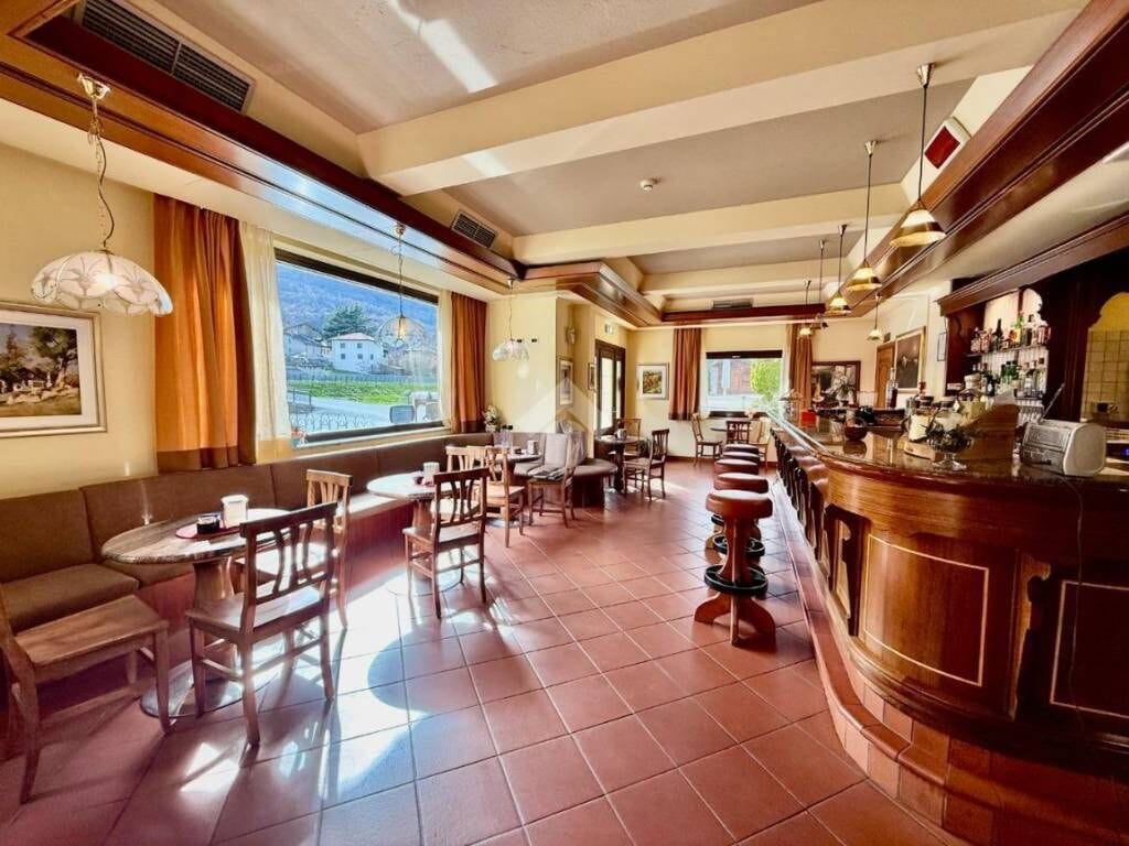 A hotel lobby with a bar area, seating arrangements, and large windows offering a view.