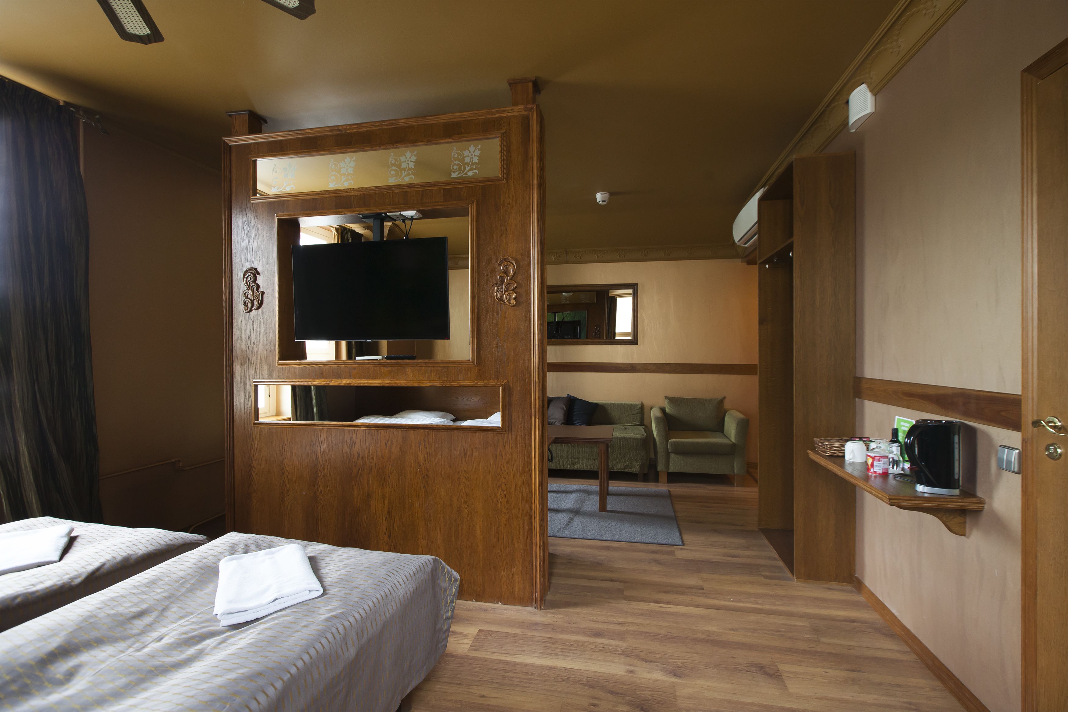 Een hotelkamer met twee bedden, een televisie, een tafeltje en een koffiezetapparaat.