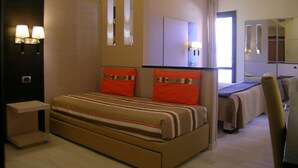 Una habitación de hotel con una cama grande, un escritorio y un espejo.