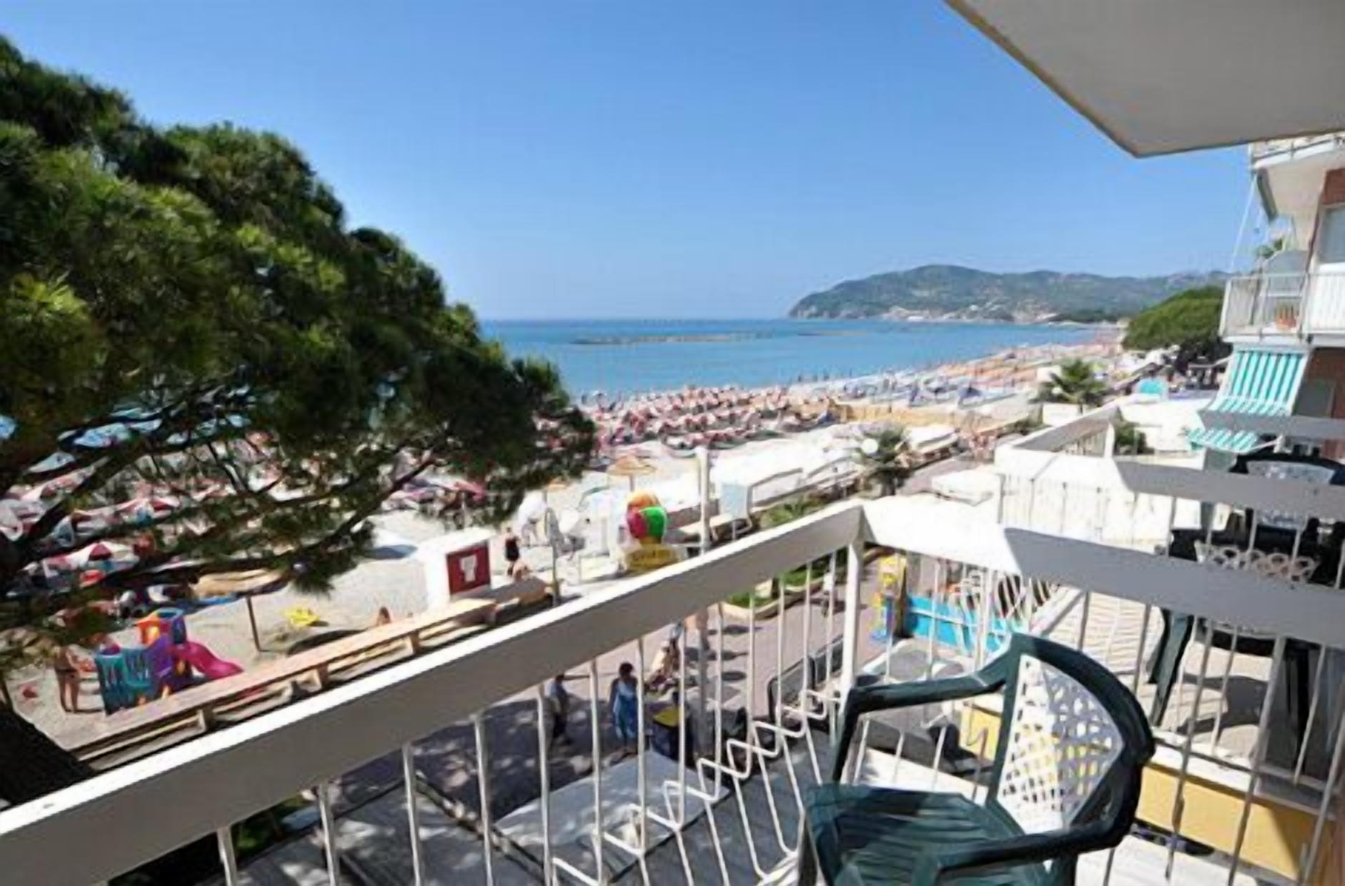 A balcony with a view of a beach and a mountain.