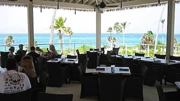 A restaurant with outdoor seating overlooking the ocean.