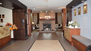 Eine Hotelhalle mit Kamin, Sitzgelegenheiten und Rezeption.