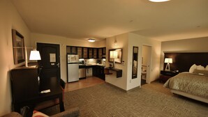 A hotel room with a bed, a desk, a chair, a small kitchenette, and a bathroom. - Staybridge Suites Liverpool Syracuse by IHG (Liverpool)