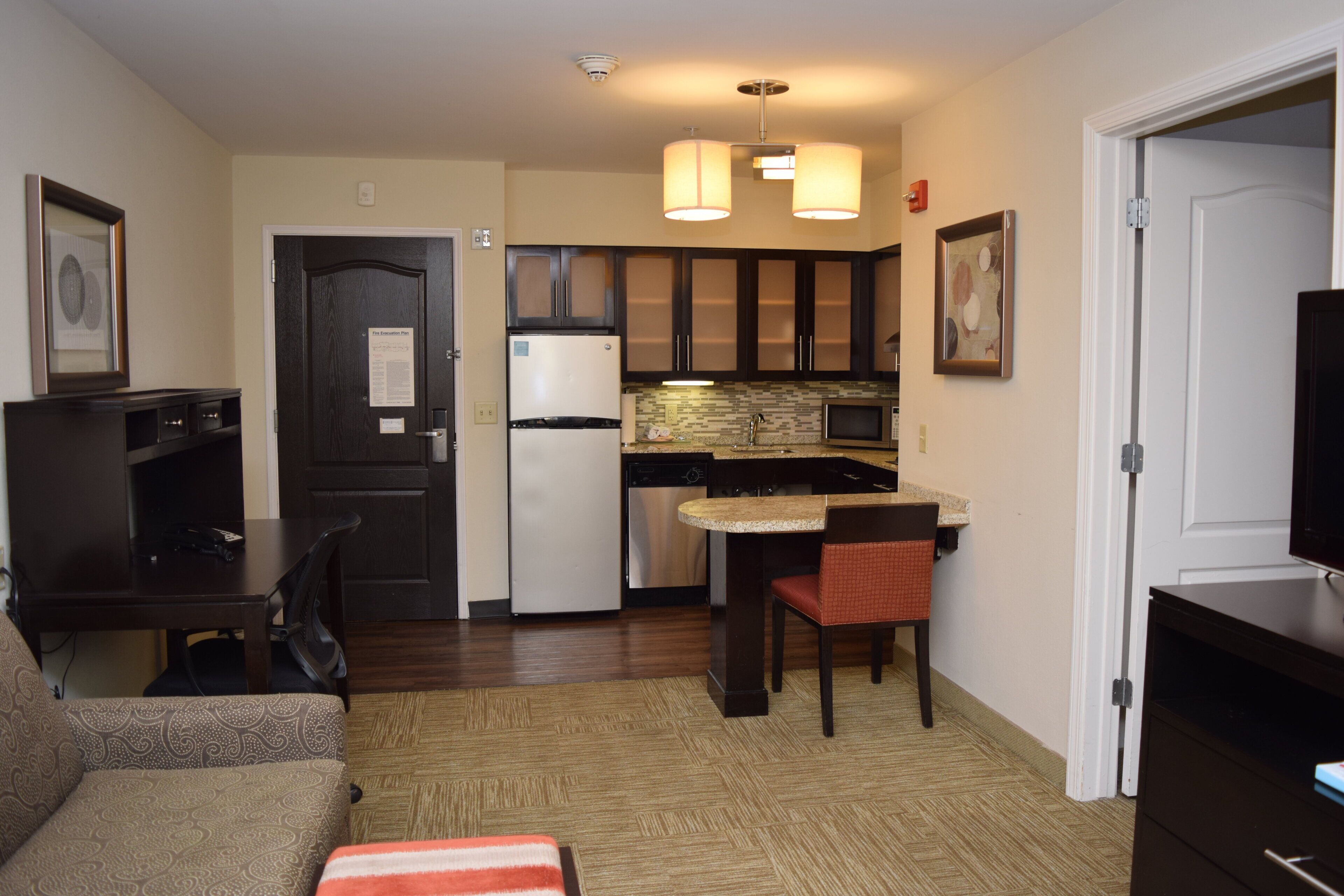Un espacio habitable compacto con kitchenette, comedor y zona de estar.