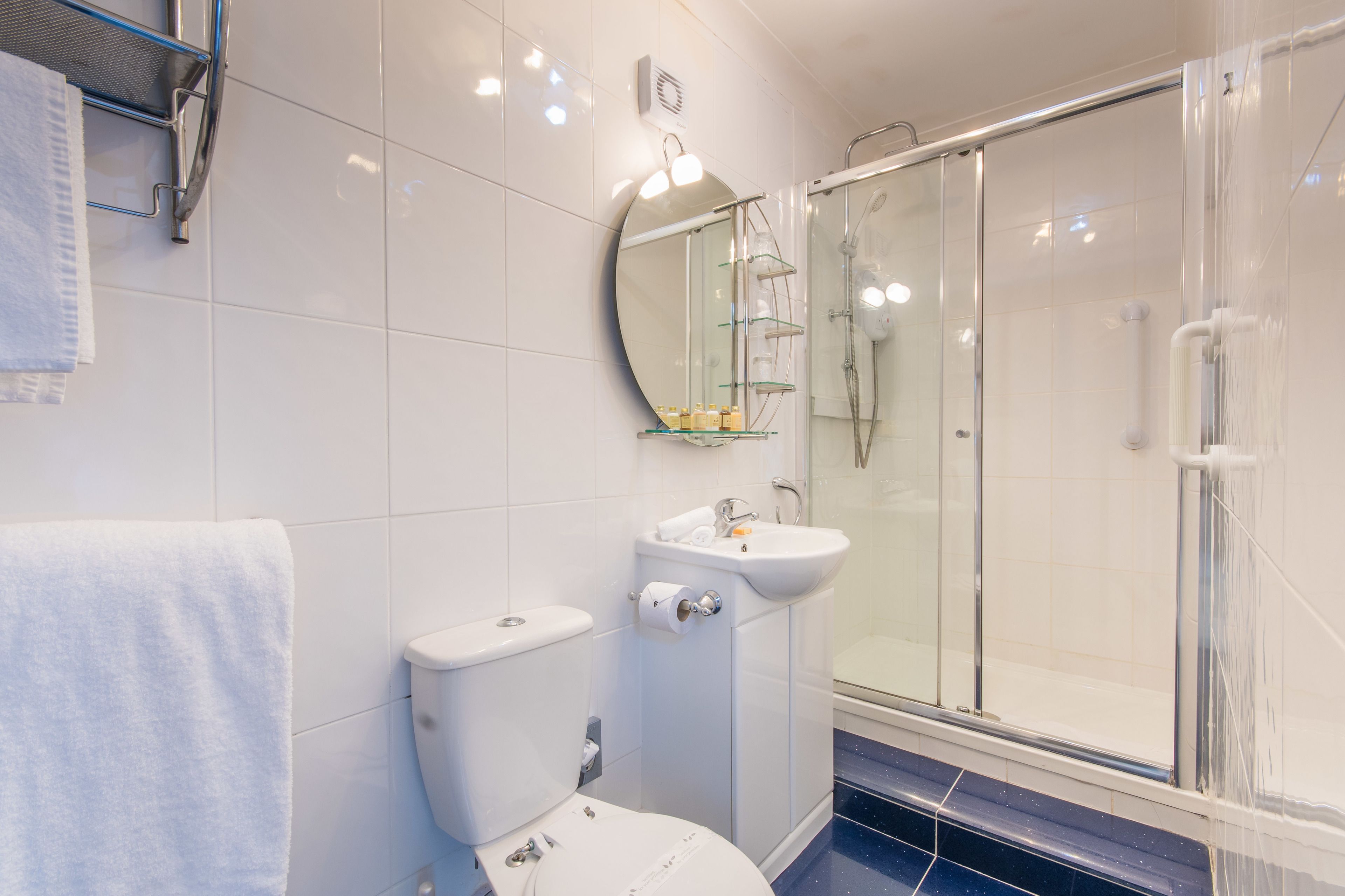 A bathroom with a toilet, sink, and glass-enclosed shower.