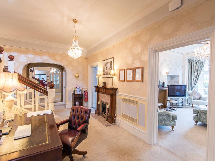 A spacious living room with a fireplace, a dining area with a wooden table and chairs, and a staircase leading to another level.