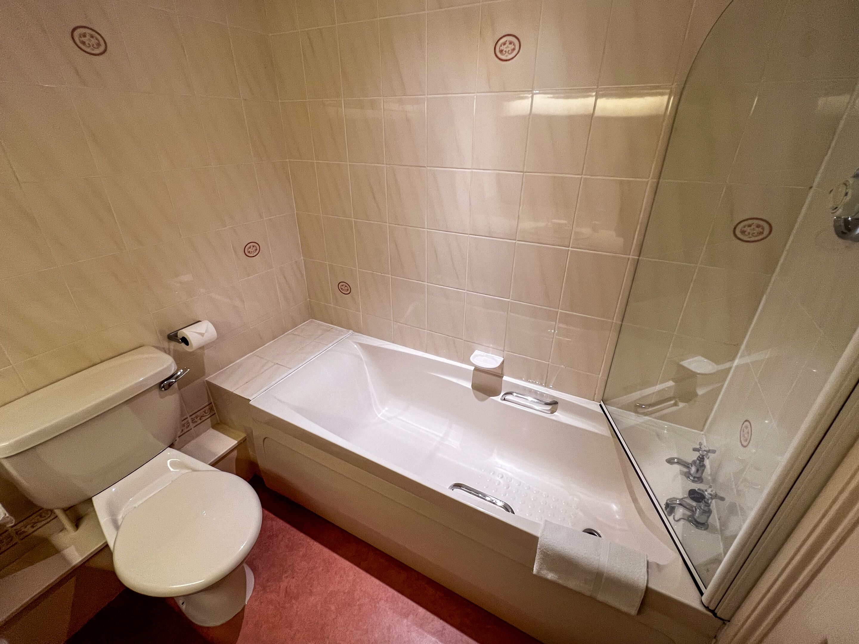 A bathroom with a toilet, a bathtub, and a shower.