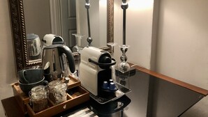 Een kitchenette met een koffiezetapparaat, waterkoker en diverse keukengerei.