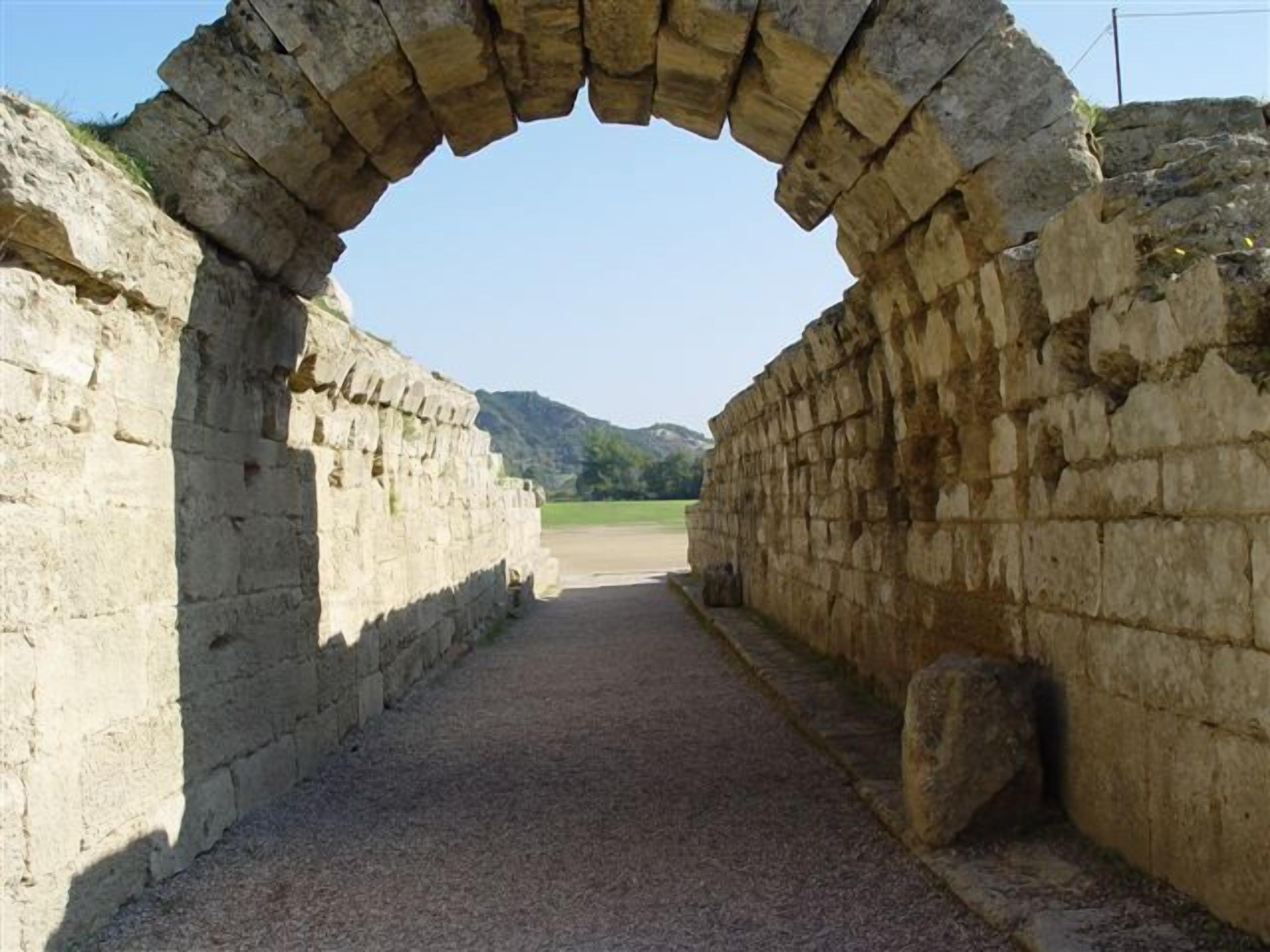 An ancient stone archway leading into a pathway.