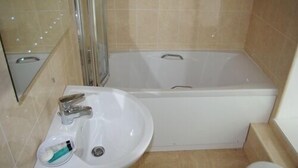 A bathroom with a white sink, a bathtub, and a toilet. - Porth Lodge Hotel (Newquay)