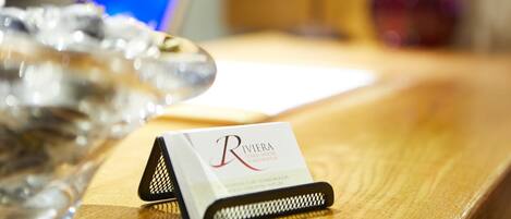 A business card on a wooden desk with a blurred background.